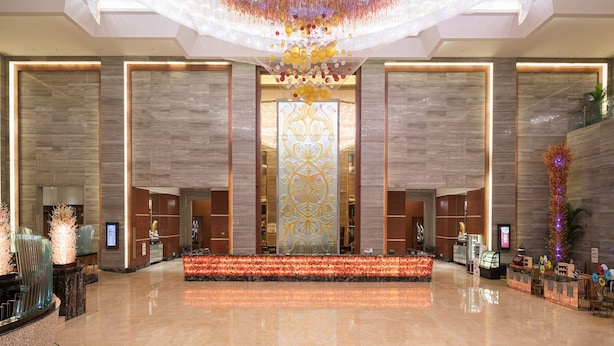 A spacious lobby with a large chandelier, a reception desk, and a decorative wall. - Cinese Hotel Dongguan Shijie (Dongguan)