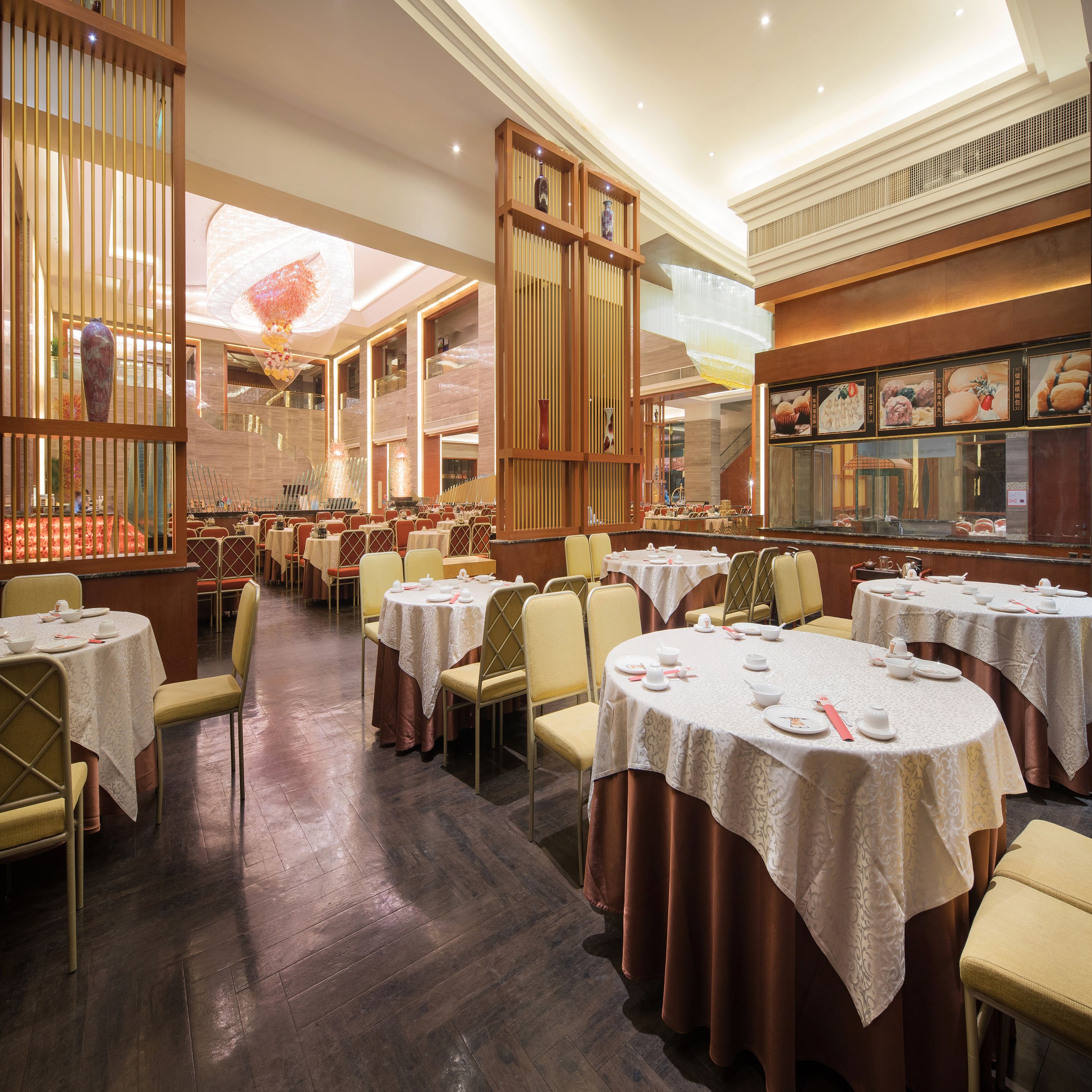 A restaurant with round tables, chairs, and a menu display.