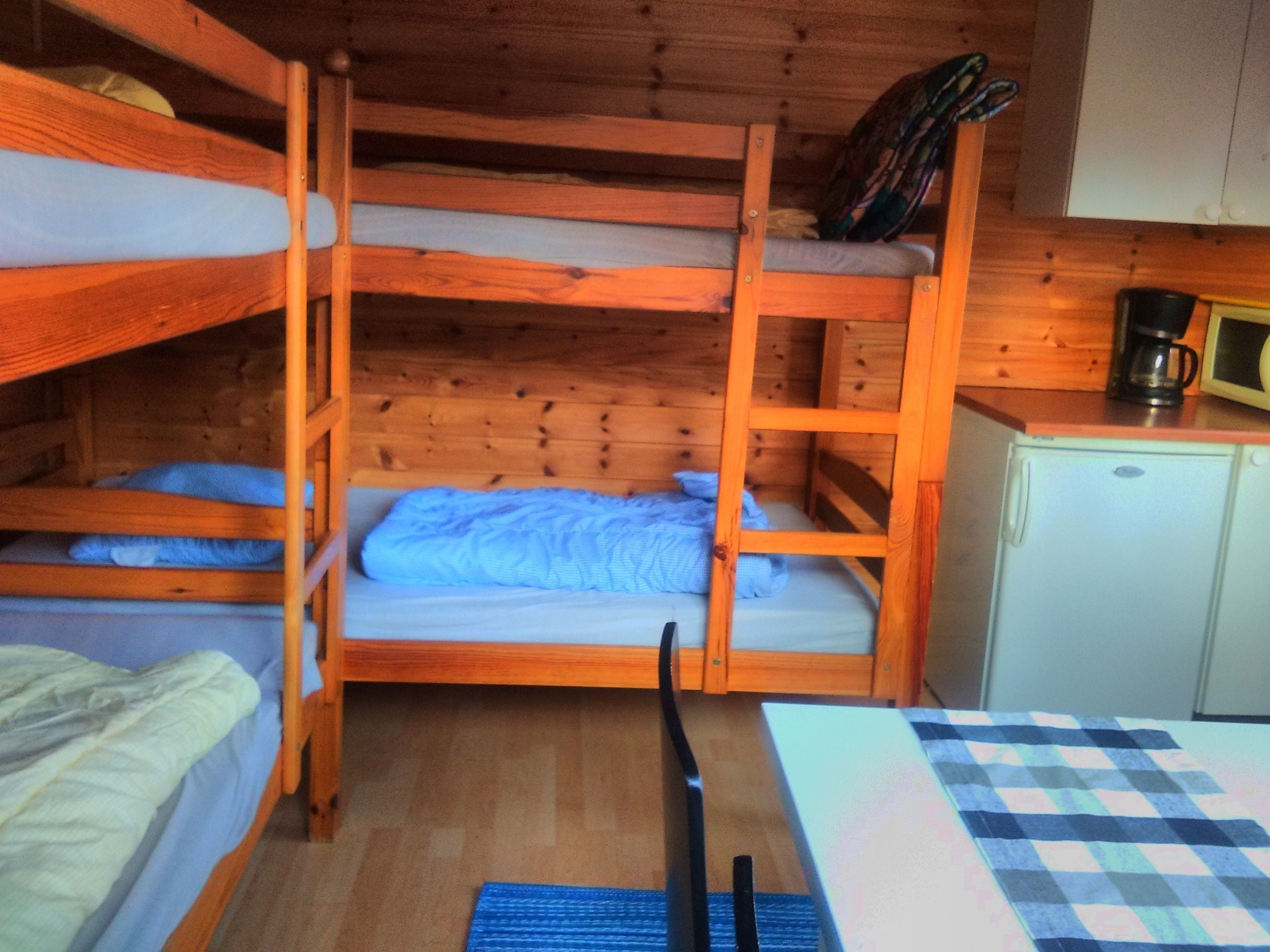 Habitación con literas, una kitchenette pequeña y un microondas.