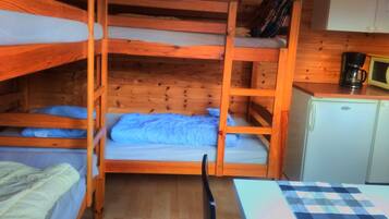 Habitación con literas, una kitchenette pequeña y un microondas.
