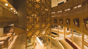A modern interior with wooden lattice structures, display cases, and artwork. - Yokkaichionsen Ofurocafe Yumoriza (Yokkaichi)