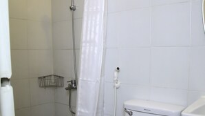 A bathroom with a shower, toilet, and sink. - Quoalla Hotel Makati (Makati)