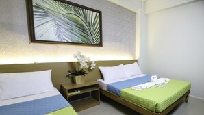 A hotel room with two beds, a nightstand with a plant, and a painting on the wall. - Quoalla Hotel Makati (Makati)