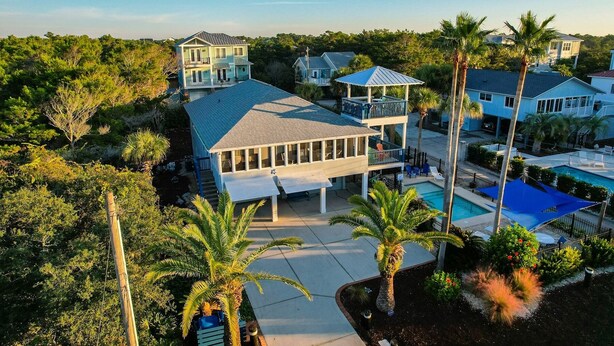 A multi-story residential building with a pool and surrounding palm trees. - Lagerheads (Panama City Beach)
