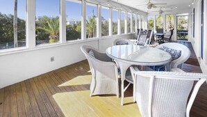 A sunlit room with large windows, wicker furniture, and ceiling fans. - Lagerheads (Panama City Beach)