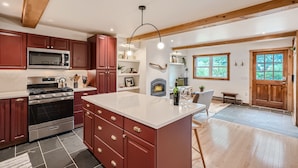 A spacious kitchen with a large island, built-in appliances, and a fireplace.