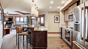 A spacious kitchen with a central island, stainless steel appliances, and a modern design. - At Base Of Peak 8, Steps From Winter Activities 3 Bedroom Condo by RedAwning (Breckenridge)