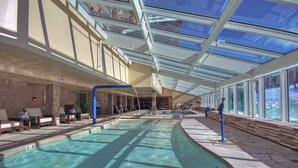 An indoor swimming pool with clear glass ceilings, sunlit areas, and lounge seating. - At Base Of Peak 8, Steps From Winter Activities 3 Bedroom Condo by RedAwning (Breckenridge)