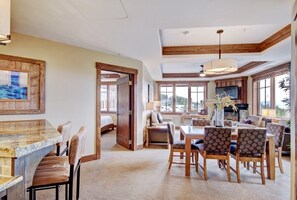 Relax in a spacious room with a dining area, cozy seating, and a mounted TV.