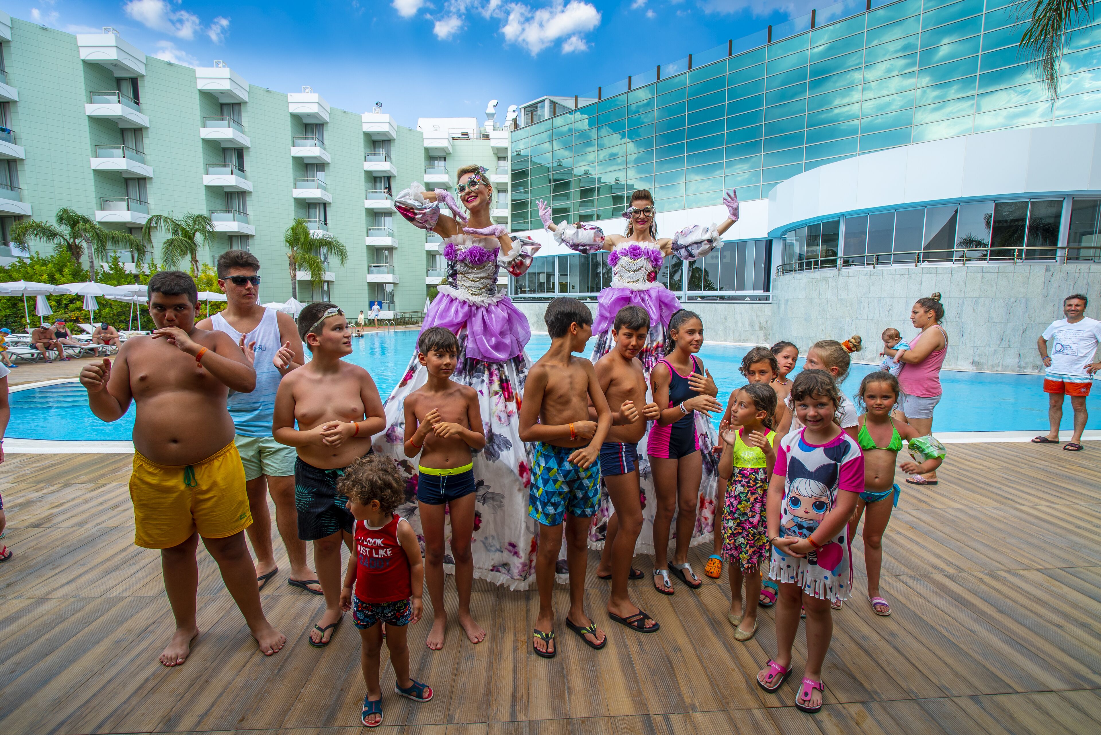 A group of people by a pool with a modern building in the background.