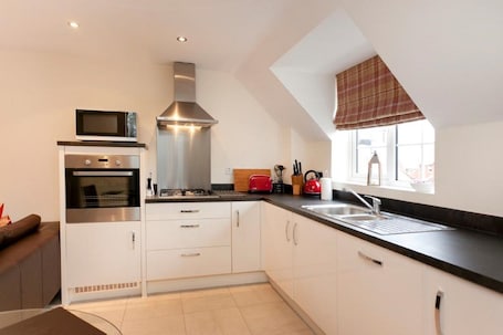 Deluxe Apartment, 2 Bedrooms | Private kitchen | Fridge, microwave, coffee/tea maker, cookware/dishes/utensils