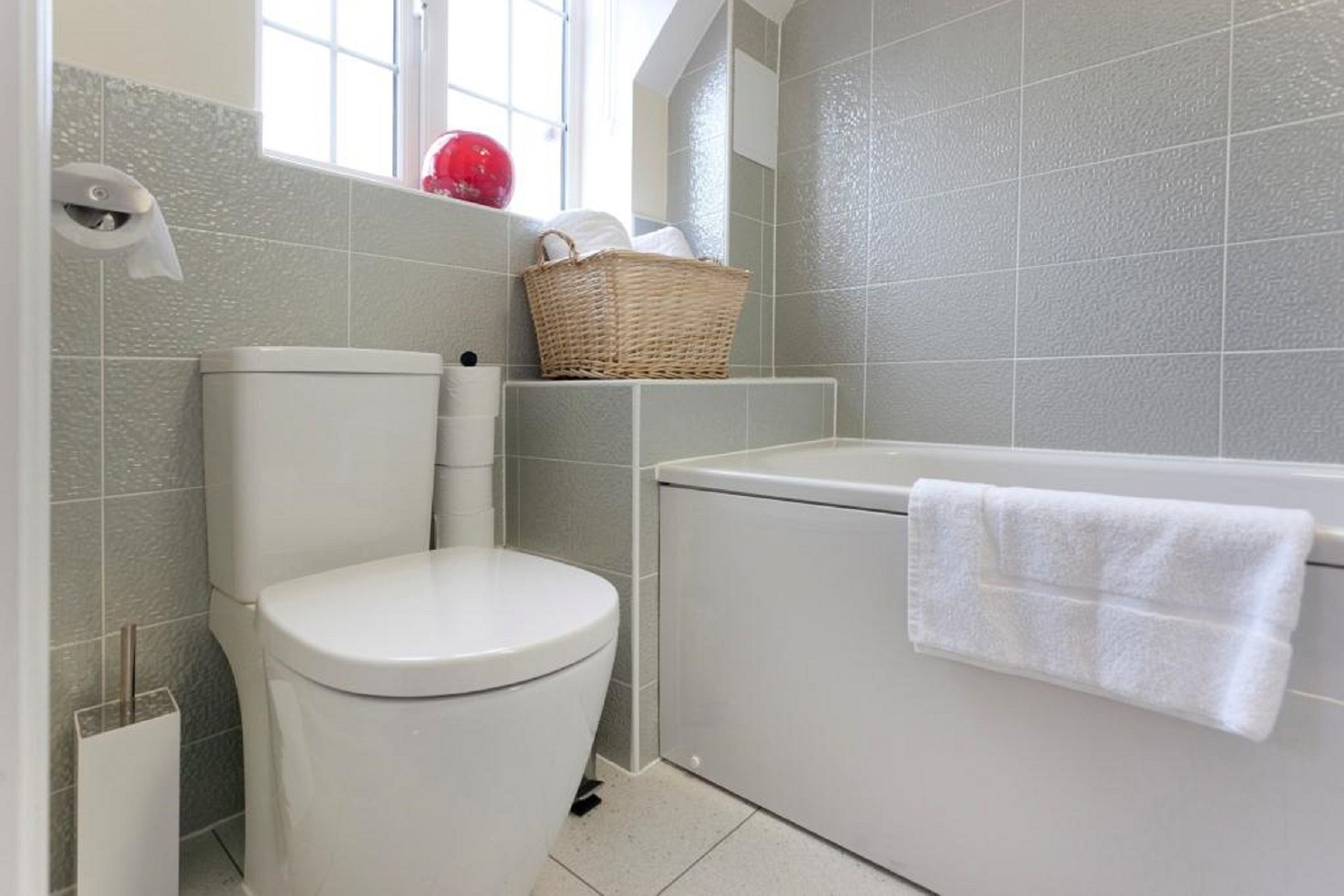 Une salle de bain avec des toilettes, une baignoire et une fenêtre.