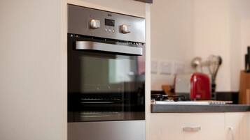 Une cuisine équipée d’un four encastré et d’un four à micro-ondes.