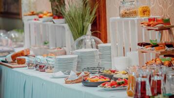 Una mesa de buffet con diversos alimentos y salsas.