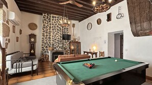 A billiards room with a pool table, a fireplace, a television, and a ceiling fan. - Palacio de Velamazán (Velamazan)