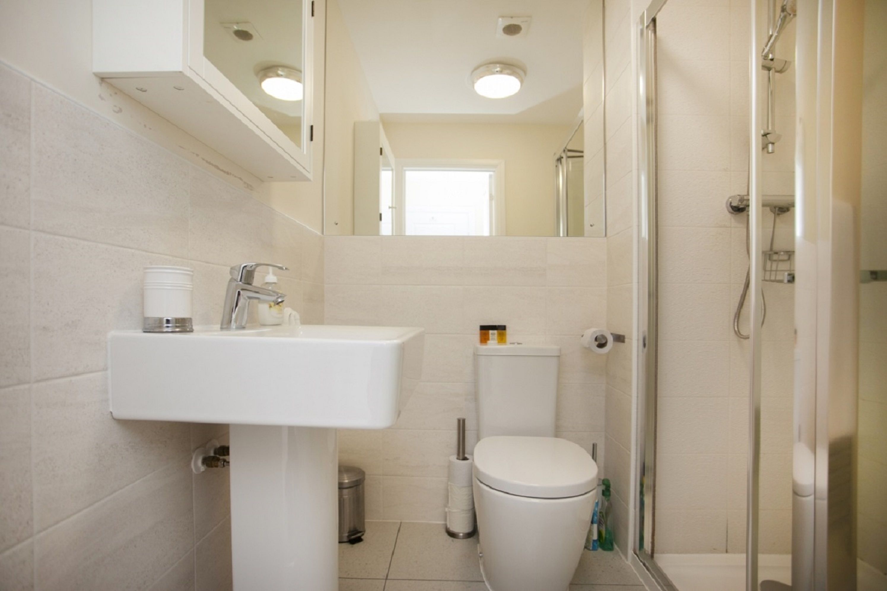 Un baño con lavamanos, inodoro y ducha.