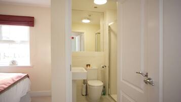A bathroom with a toilet, sink, and shower.