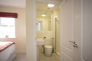 A bathroom with a toilet, sink, and shower.