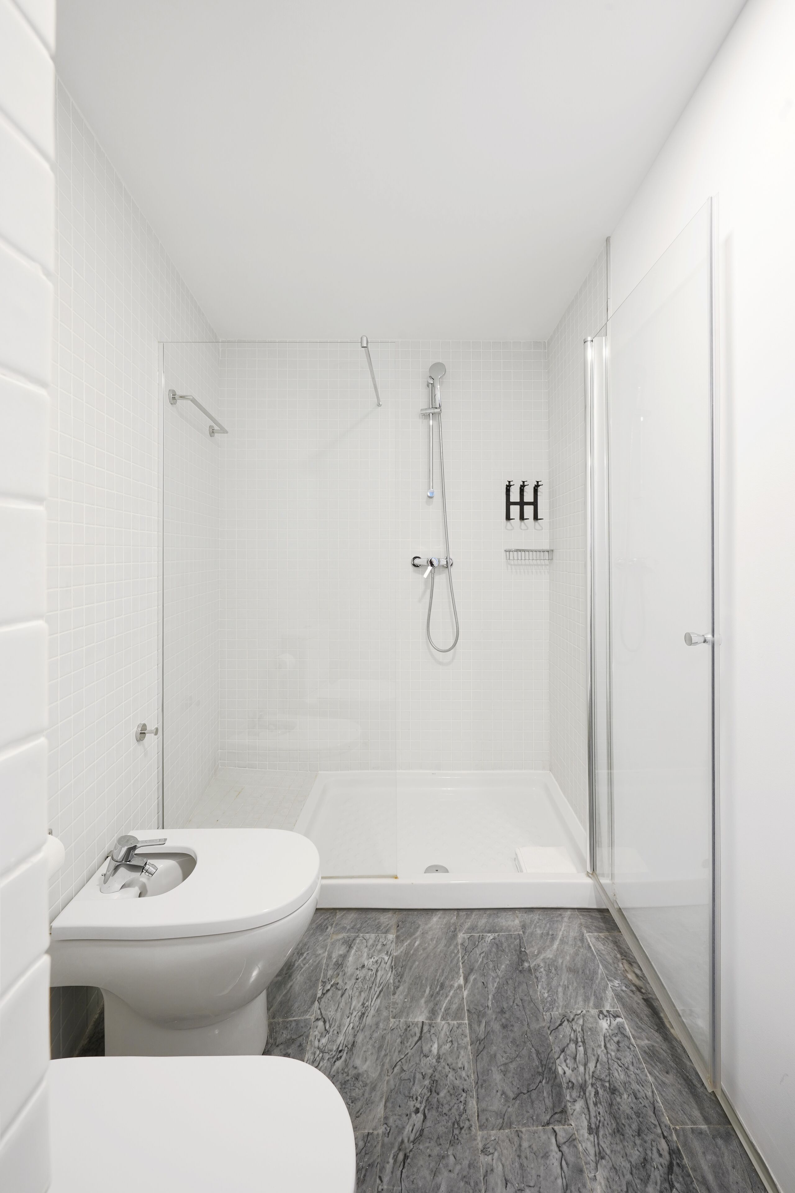Une salle de bain moderne équipée d’une douche, de toilettes et d’une baignoire.