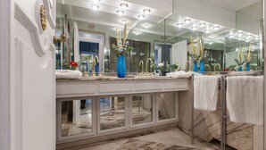 A modern bathroom with a large mirror, gold faucets, and a marble countertop. - Rental in Rome Flaminio View Suite (Rome)