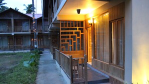 Un edificio con fachada de madera, un balcón y una escalera que lleva a la entrada.