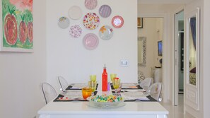 A dining area with a white table, clear glassware, and a bowl of colorful snacks. - Rental in Rome Parma (Rome)