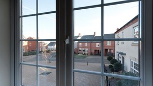 A view through a window with a clear view of a residential area with houses and a paved courtyard. - The Townhouse (Derby)
