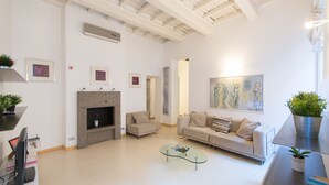 A modern living room with a fireplace, a glass coffee table, and a sofa.