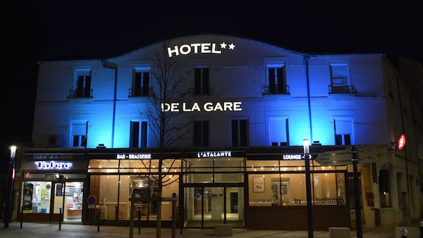 A hotel with a prominent "HOTEL" sign, "DE LA GARE" signage, and a "BAR - BRASSERIE" and "L'ATALANTE" establishment at the ground level. - Hotel de la Gare – urban by balladins (Chateauroux)