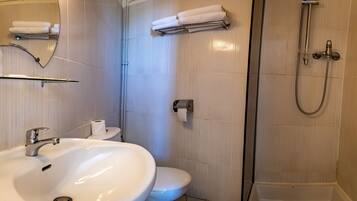 A bathroom with a sink, toilet, and shower.