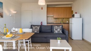 Un appartement compact comprenant un coin repas, un canapé et une kitchenette.