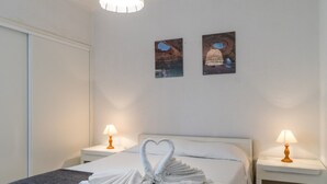 Une chambre d’hôtel avec un lit, deux lampes de chevet et deux tableaux encadrés accrochés au mur.