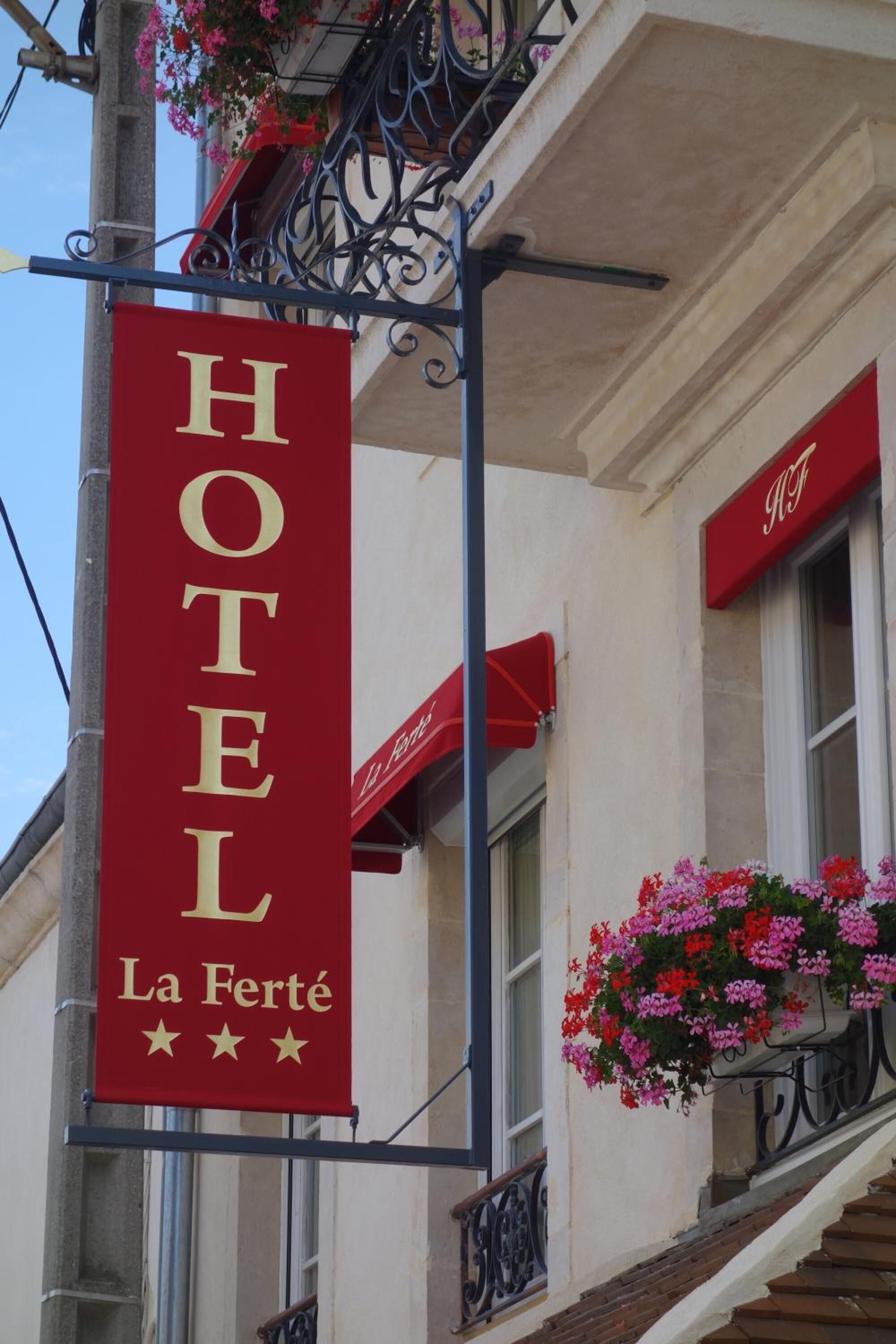Un letrero de hotel que dice "HOTEL La Ferté" y muestra tres estrellas.