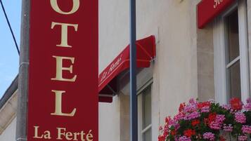 Un letrero de hotel que dice "HOTEL La Ferté" y muestra tres estrellas.