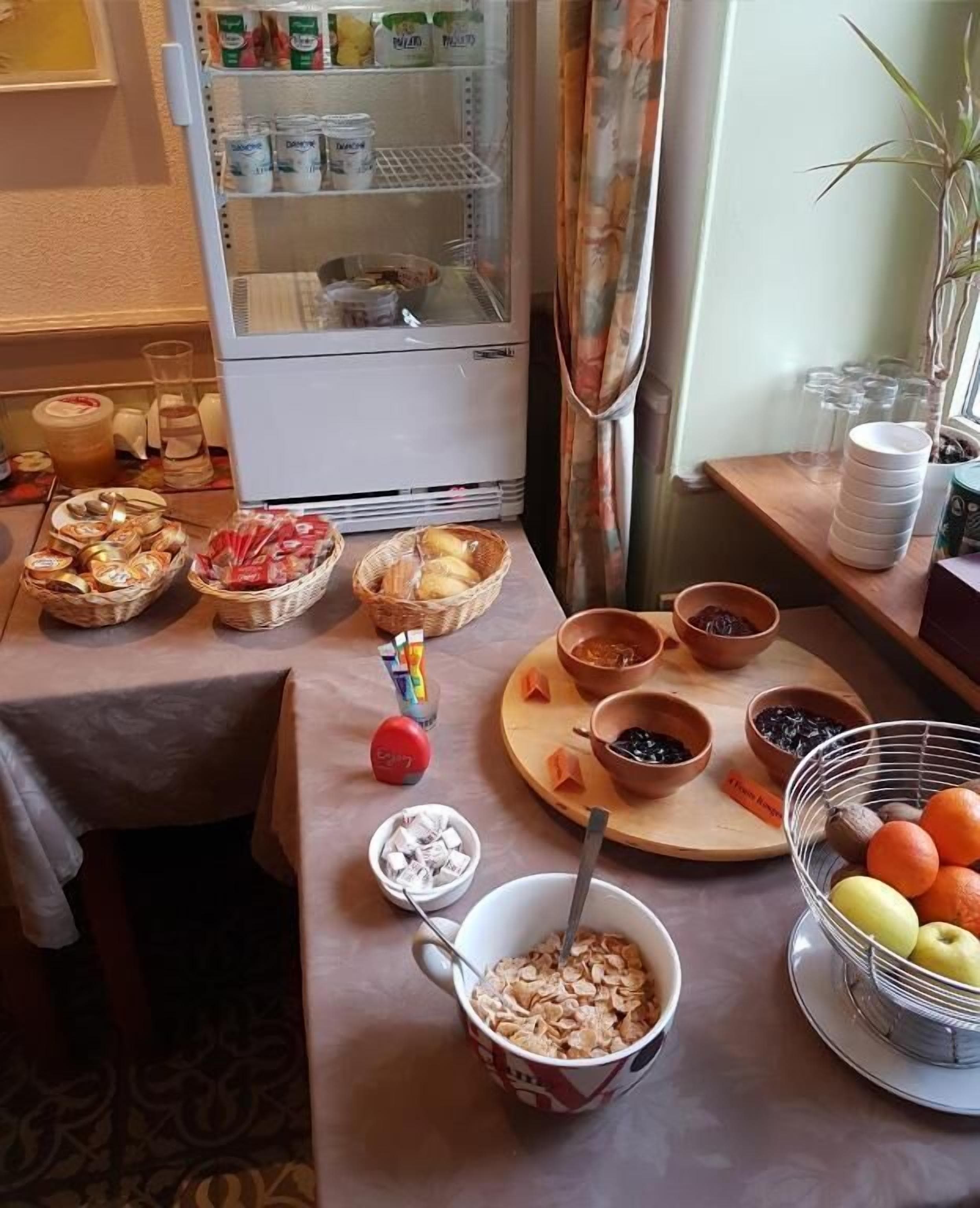 A breakfast buffet with various food items, including cereal, fruits, and pastries.