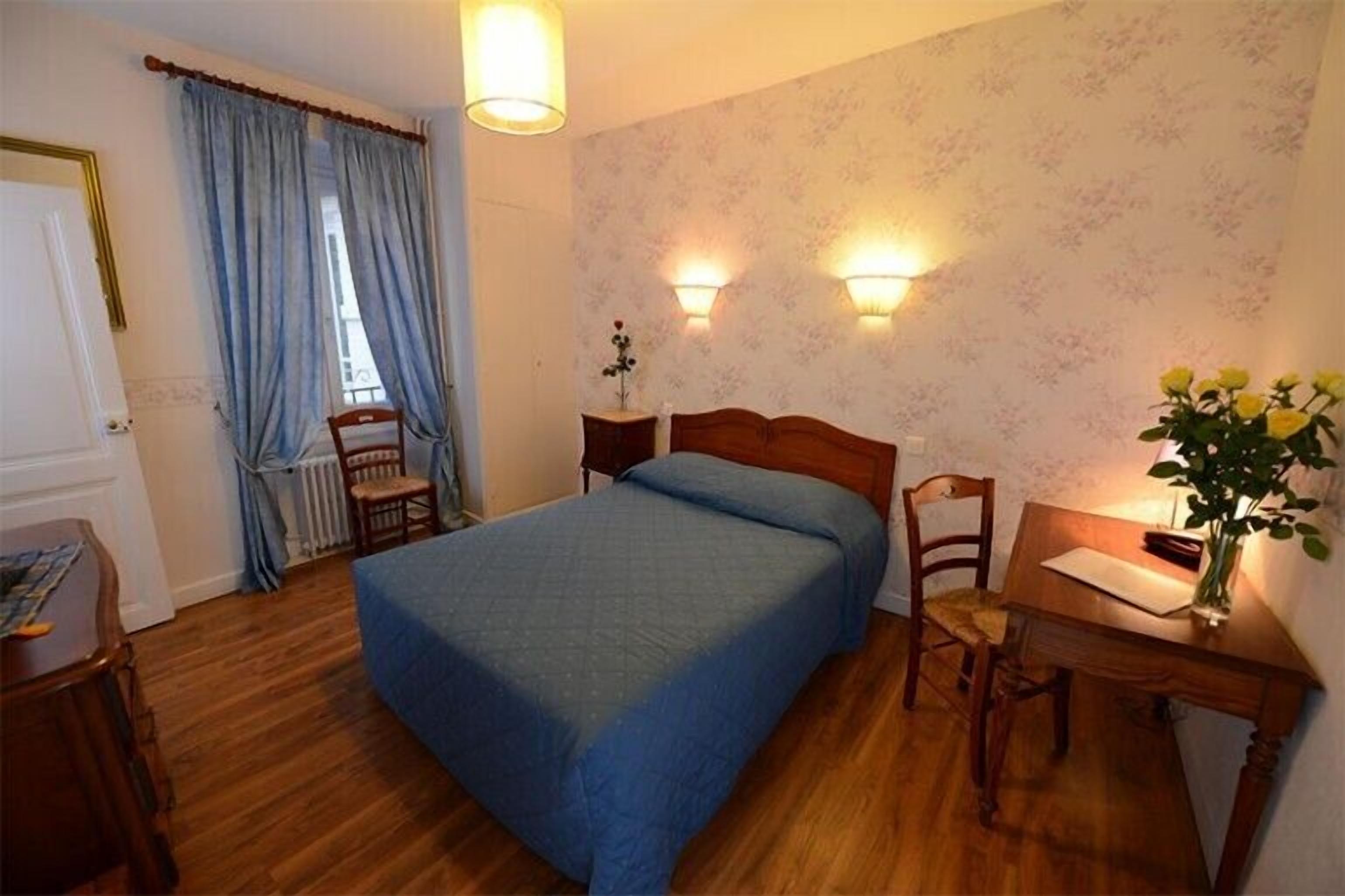 Une chambre à coucher avec un lit, un bureau, une chaise et un radiateur.
