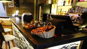 Zona de bar con mostrador, sillas y una cesta de aperitivos.