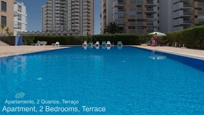 Uma piscina com espreguiçadeiras e um terraço.