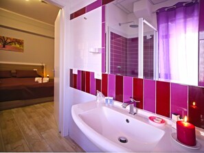 A modern bathroom with a large white sink, a mirror, and a shower area. -  ORCHIDEA HOUSE FIUMICINO two (Fiumicino)