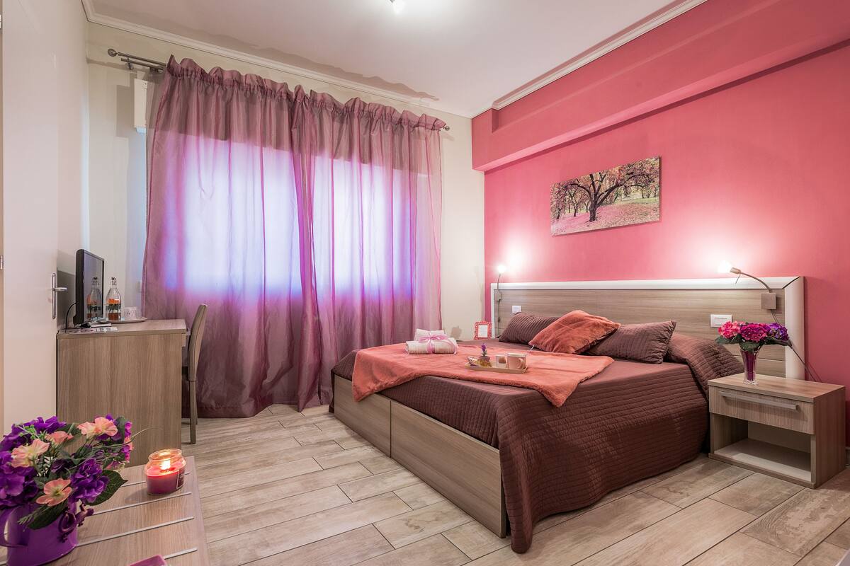 A bedroom with a bed, bedside table, and a desk with a chair.