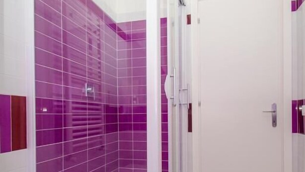 A modern bathroom with a glass shower enclosure, white walls, and purple tiles. -  ORCHIDEA HOUSE FIUMICINO two (Fiumicino)