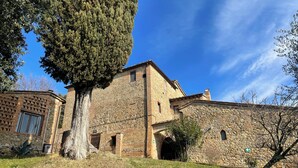 Un edificio de piedra con un gran árbol en primer plano.