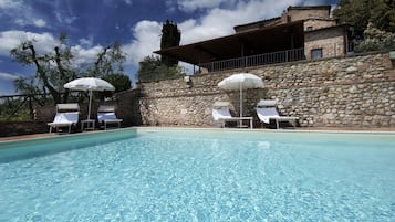 Una piscina al aire libre, tumbonas