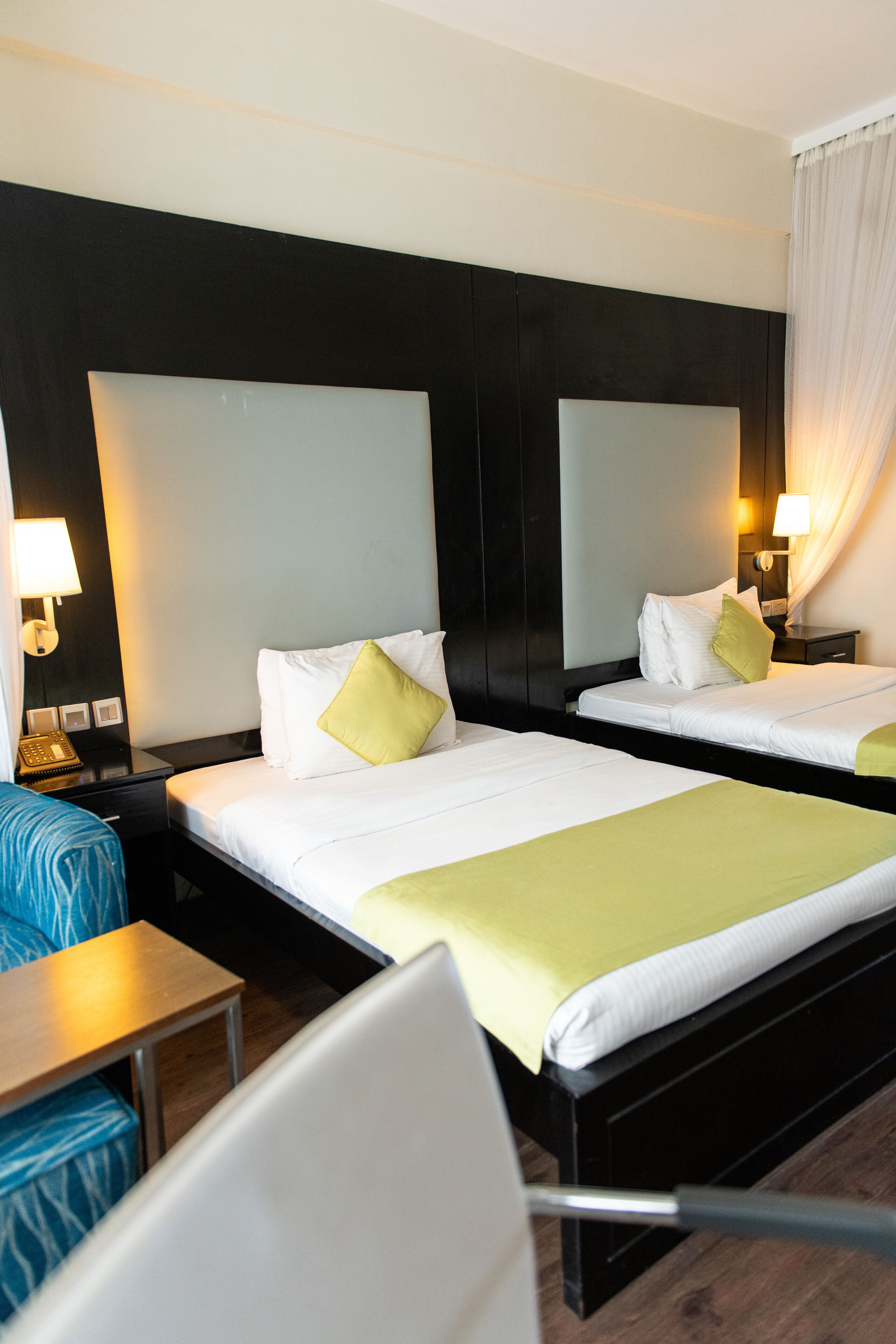 Habitación de hotel con dos camas, un escritorio y una silla.