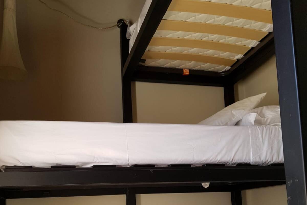 A bunk bed room with two beds, a patterned floor, and a door with a handle.