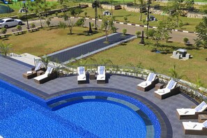 A swimming pool with lounge chairs and a paved walkway. - The Grand Mountain Hotel (Matale)