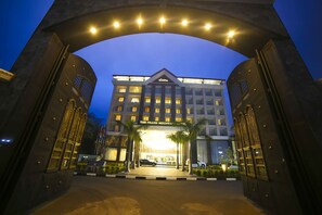 A hotel entrance with a grand archway, multiple floors, and a well-lit facade. - The Grand Mountain Hotel (Matale)