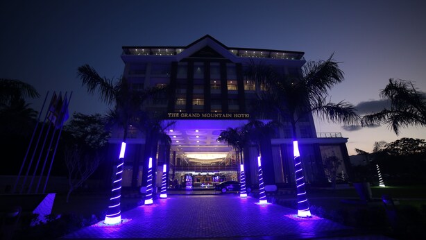 The Grand Mountain Hotel entrance with a modern design, featuring a prominent entrance and illuminated pillars.