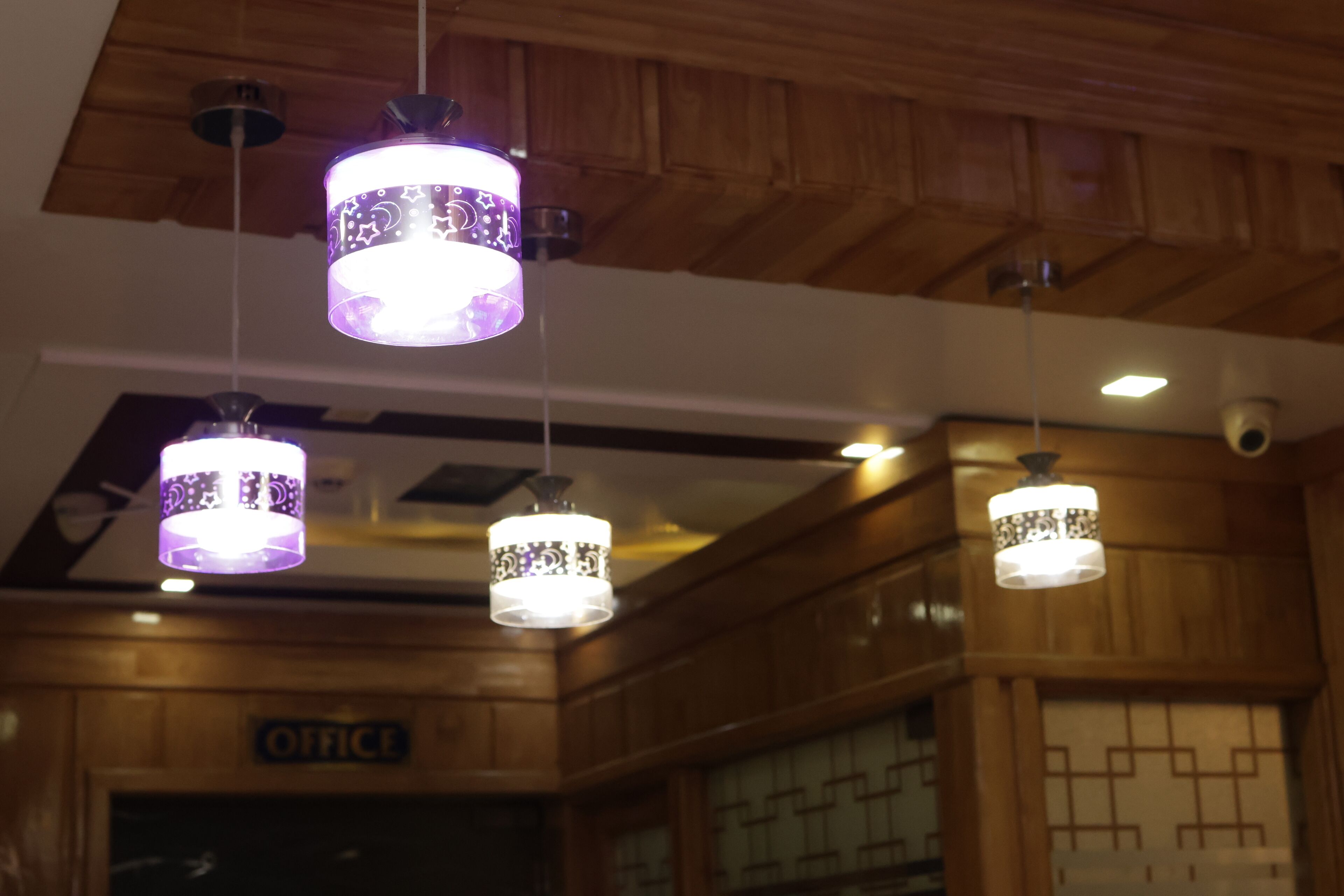 A ceiling with three hanging pendant lights with patterned shades.