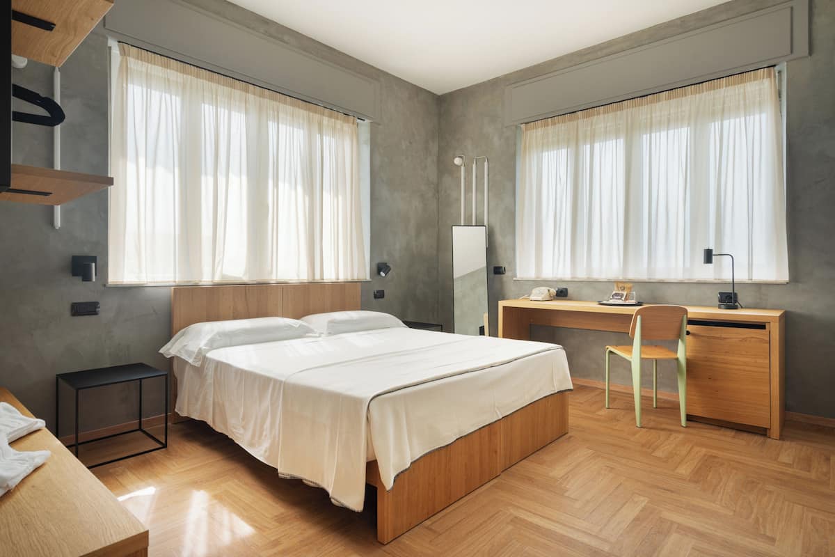 Une chambre à coucher avec un lit, un bureau, une chaise et une petite table.